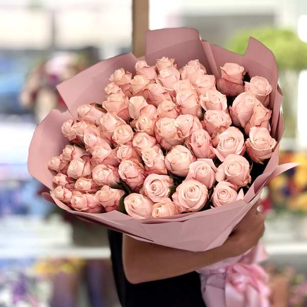 Large bouquet of pale pink roses wrapped in pink paper