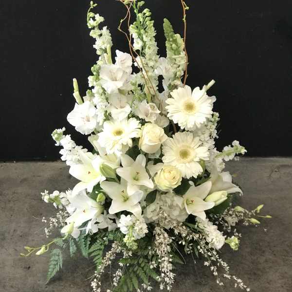 White floral arrangement with lilies, gerbera daisies, and roses