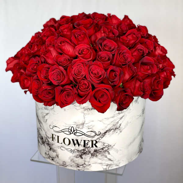 Large bouquet of red roses in a marble-patterned box