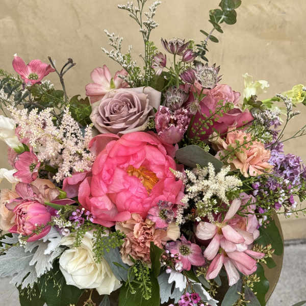 Mixed pink and white floral arrangement in a gold pedestal vase