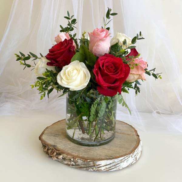 Bouquet of red, pink, and white roses in a glass vase