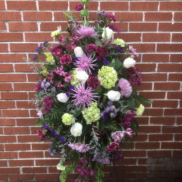 Large standing floral spray with purple, white, and green blooms