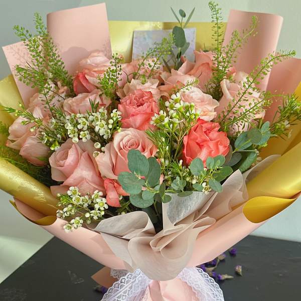 Pink rose bouquet wrapped in blush paper with lace ribbon