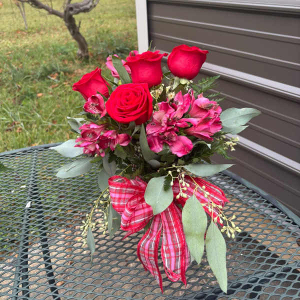 Bouquet of red roses and pink flowers with a plaid ribbon
