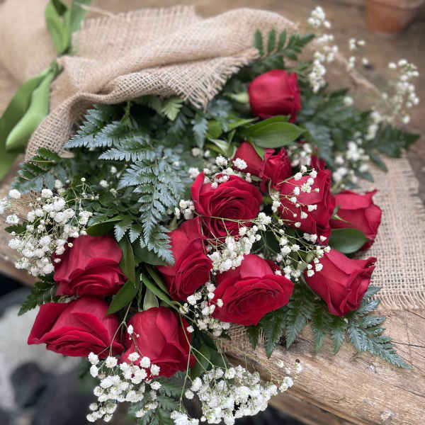 Bouquet of red roses with baby's breath wrapped in burlap