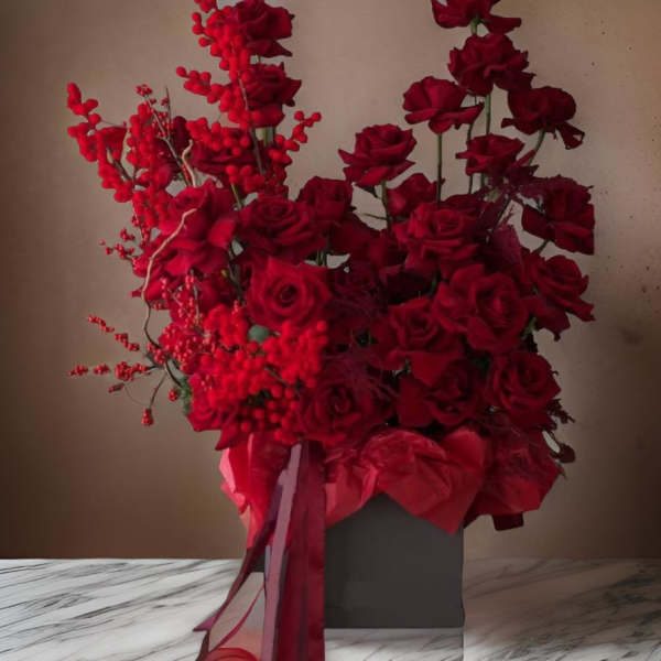 Red rose arrangement in a gray box with ribbon