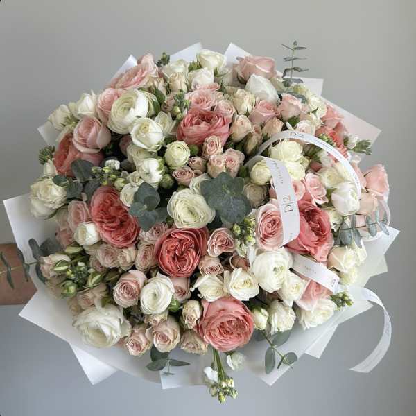 Large bouquet of pink and white roses wrapped in white paper