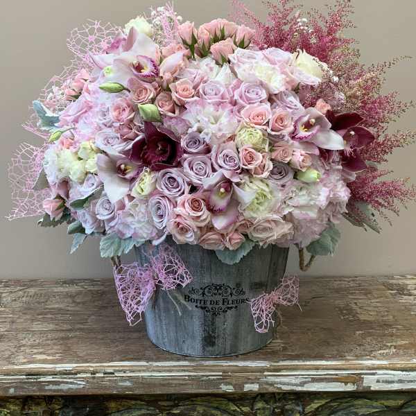 Pink and lavender floral arrangement in a metal bucket