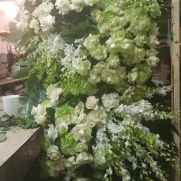Large white and green floral arrangement with cascading blooms