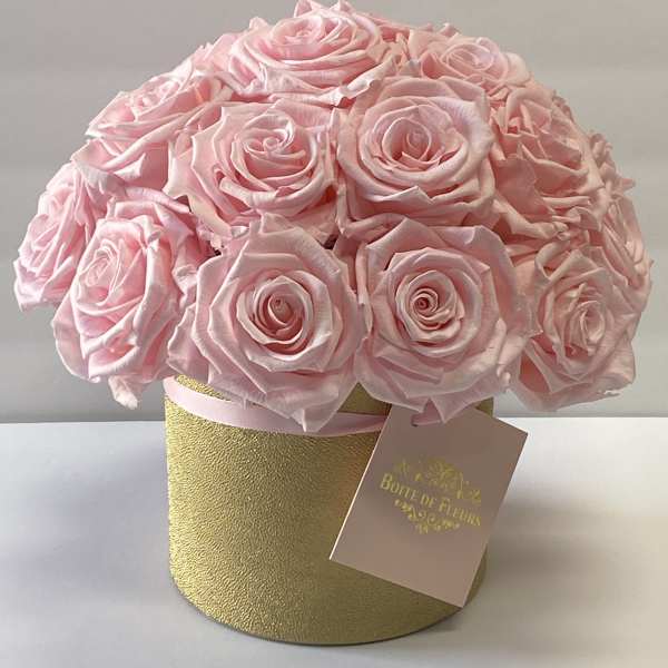 Pink rose bouquet in a gold round box with a hanging tag