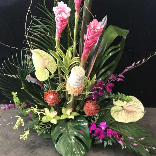 Tropical floral arrangement with pink ginger, anthuriums, and orchids