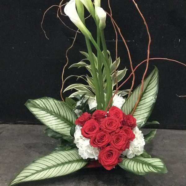 Red roses and white calla lilies in a tall floral arrangement