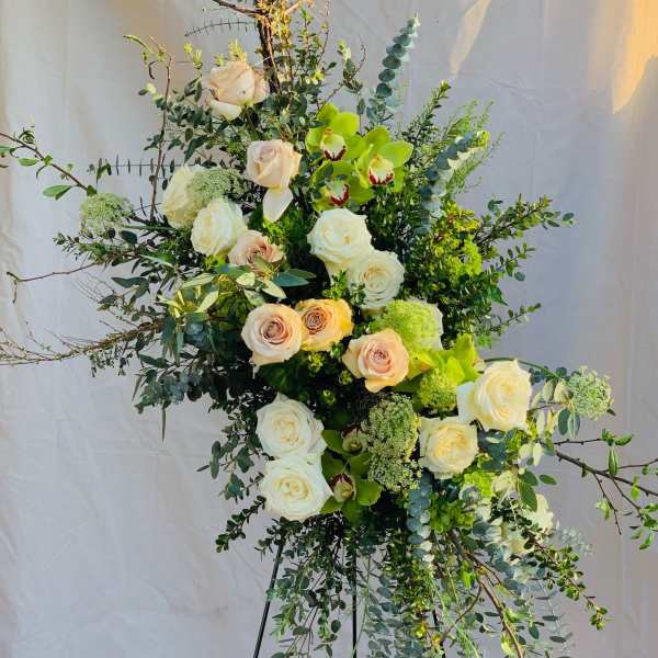 Tall floral spray with white roses, pale orchids, and greenery