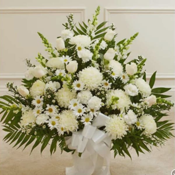 White floral standing spray with daisies, carnations, and roses