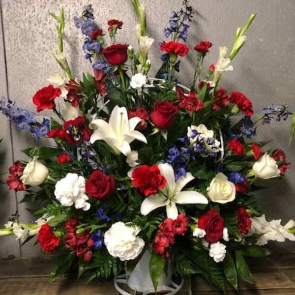 Large red, white, and blue floral spray in a white container