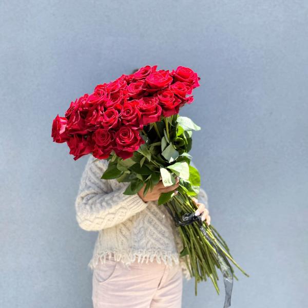 Large bouquet of red roses held by a person