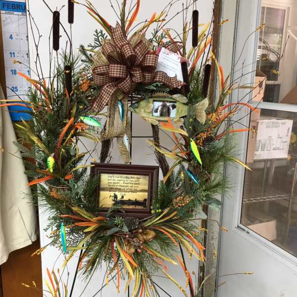 Tall decorative wreath with fish accents, ribbon, and a framed sign
