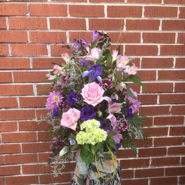 Tall mixed bouquet with pink and purple flowers in a decorative wrap