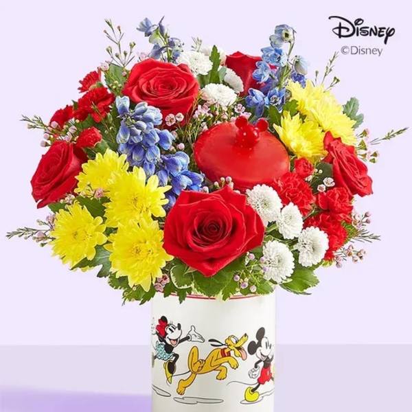 Colorful bouquet of roses, chrysanthemums, and blue flowers in a Disney Mickey and Friends container