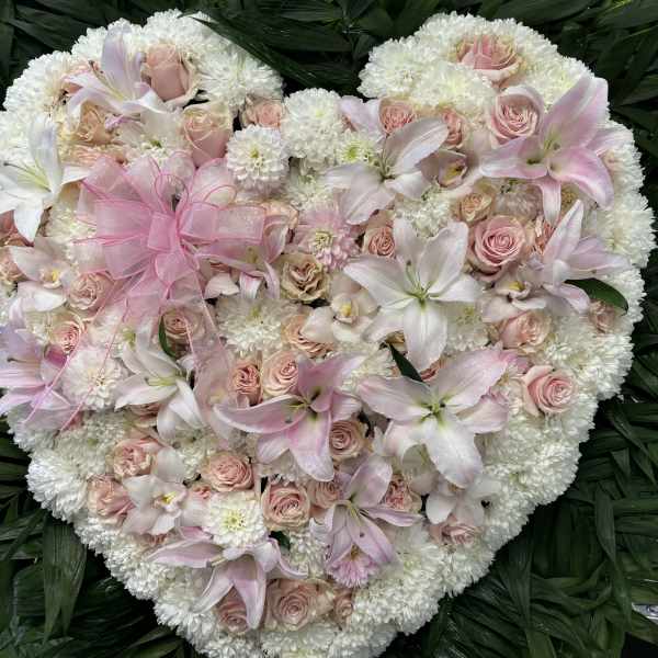 Heart-shaped floral arrangement with pink roses and white lilies