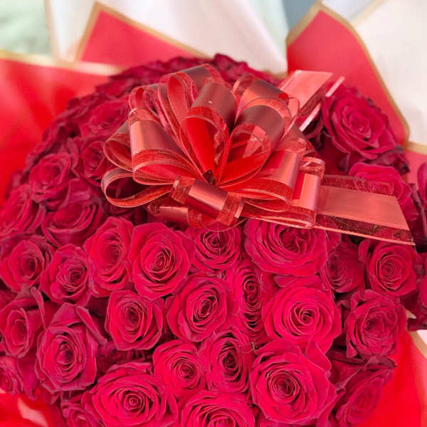 Large bouquet of red roses with a decorative ribbon bow