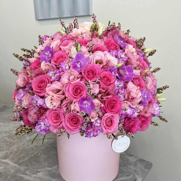 Pink and purple rose bouquet in a pale pink hat box
