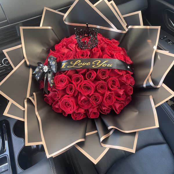 Bouquet of red roses wrapped in black paper with gold trim