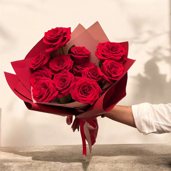Bouquet of red roses wrapped in burgundy paper
