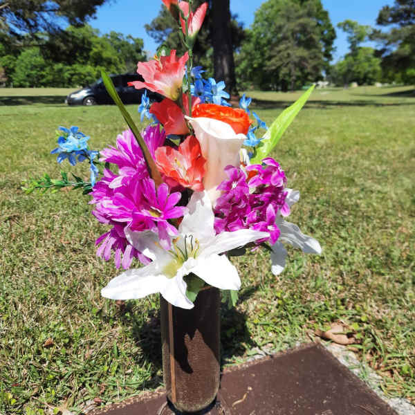 Colorful flower arrangement placed on a grave marker outdoors