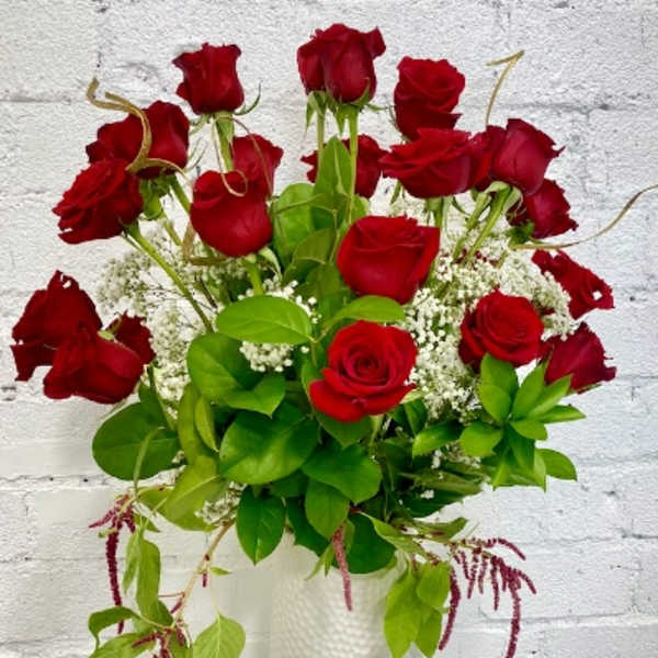 Red roses arranged in a white textured vase
