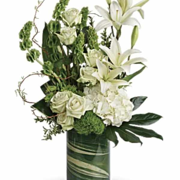 White lilies and roses arranged in a glass vase