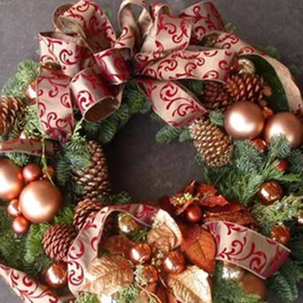 Decorated evergreen wreath with pinecones, ornaments, and red patterned ribbon