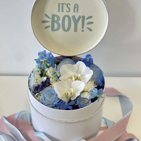 Round box of blue and white flowers with an "It's a Boy!" topper