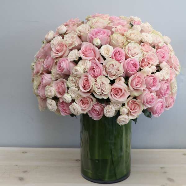 Pink and cream rose bouquet in a tall glass vase