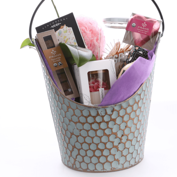 Gift basket with chocolates, candles, and a pink orchid stem