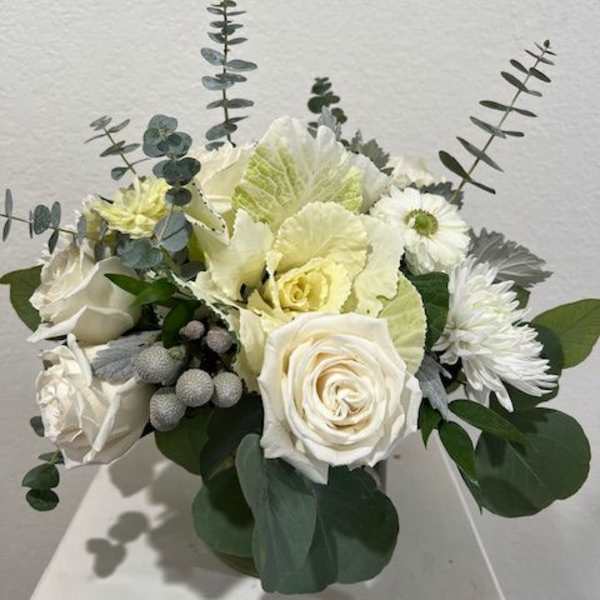 White rose and chrysanthemum bouquet with eucalyptus in a low container