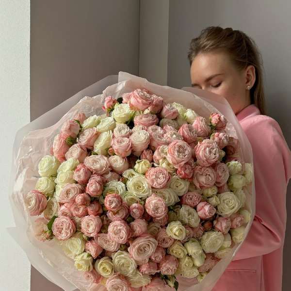 Large bouquet of pale pink and cream roses wrapped in tissue paper