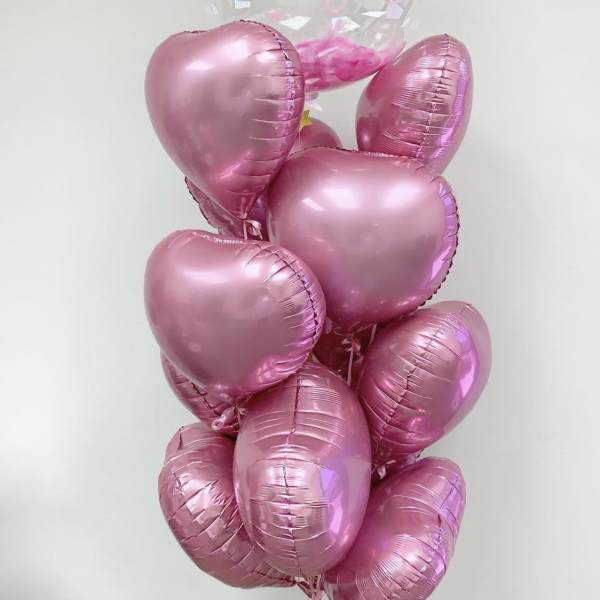Cluster of pink heart balloons with a clear Happy Birthday balloon on top