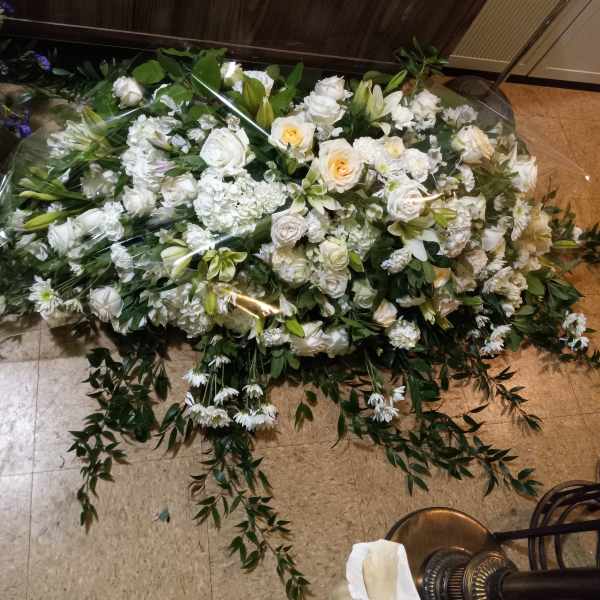 Large white floral spray with roses and lilies on the floor