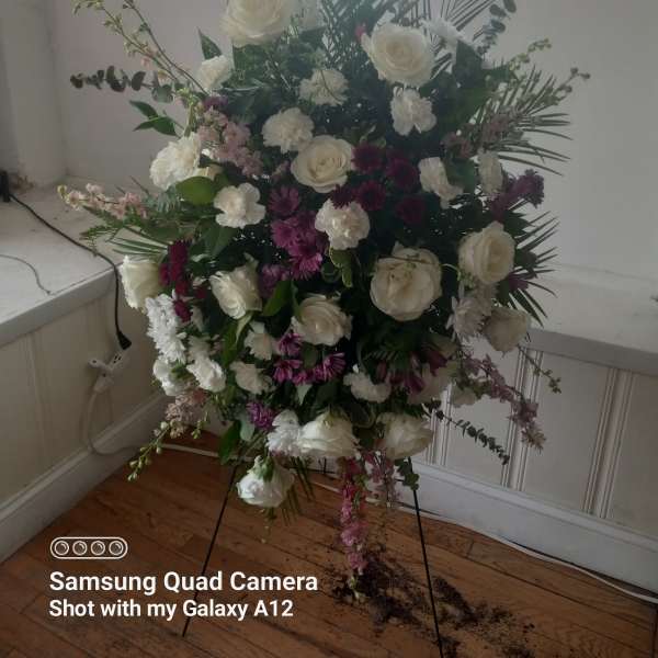 Tall floral spray with white roses and pink-purple flowers on a stand