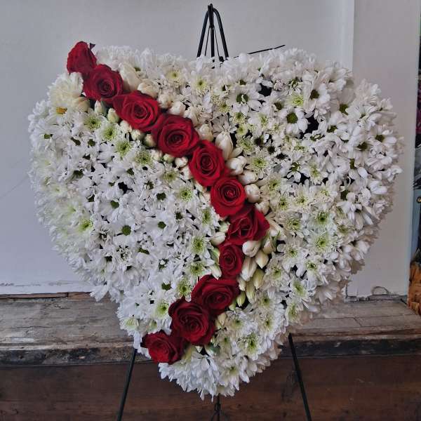 Heart-shaped floral spray with red roses and white daisies