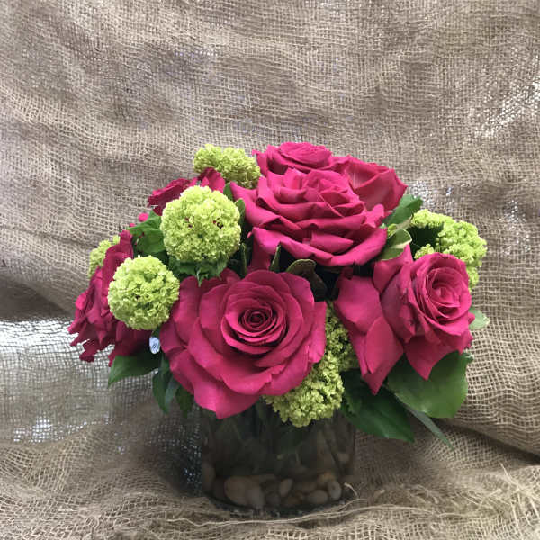 Pink roses with green pom-pom flowers in a glass vase