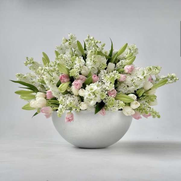 White and pink floral arrangement in a round silver bowl