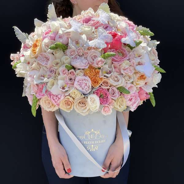 Large pastel bouquet of roses and orchids in a blue hat box