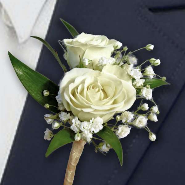 White rose boutonniere with baby's breath and green leaves