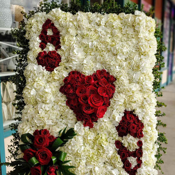 Large floral display of white hydrangeas with red rose hearts