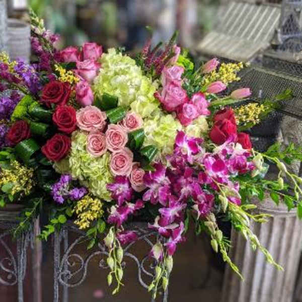Large mixed bouquet with pink and purple flowers in a decorative container