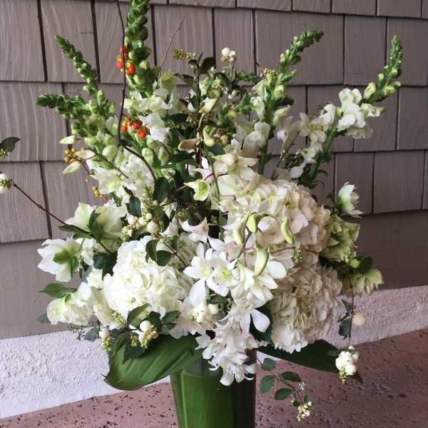 Tall white floral arrangement in a green vase