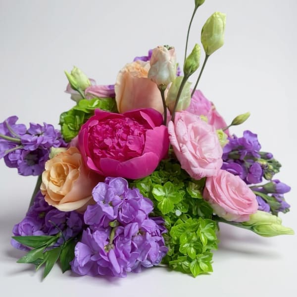 Bouquet of pink, purple, and peach flowers with green accents