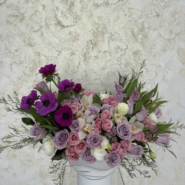 Lavender and pink roses with purple anemones in a white vase